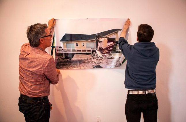 Anthony Aziz, left, the director of the BFA Fine Arts program at Parsons, helps student Robert Hickerson hang a piece for the benefit show. Photo: Natalie Keyssar for The Wall Street Journal